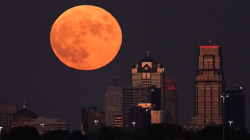 FILE - A full Hunter's Moon rises beyond downtown buildings, Sunday, Oct. 9, 2022, in Kansas...